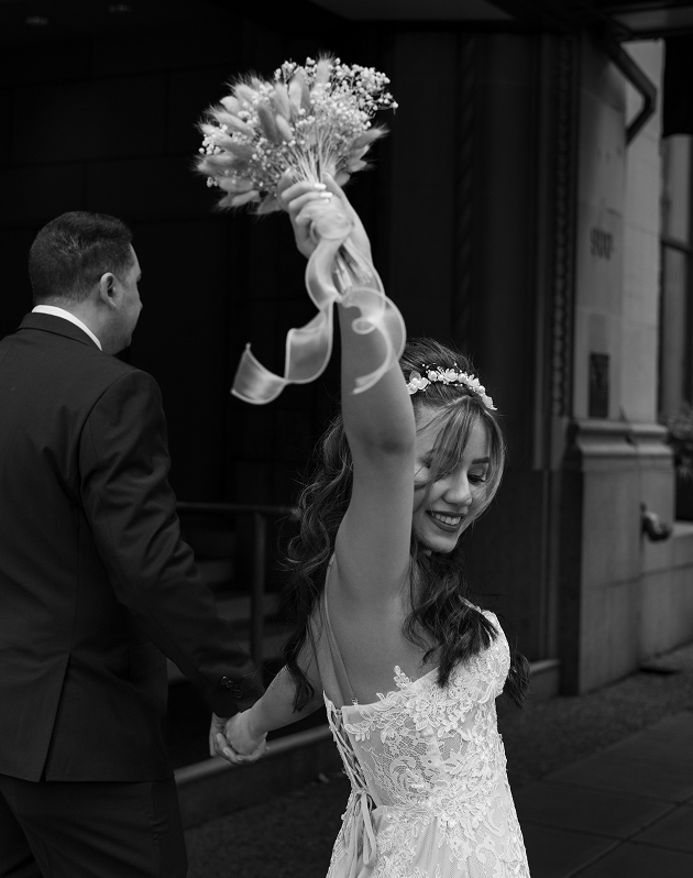 portrait of a bride cheering with her bouquet